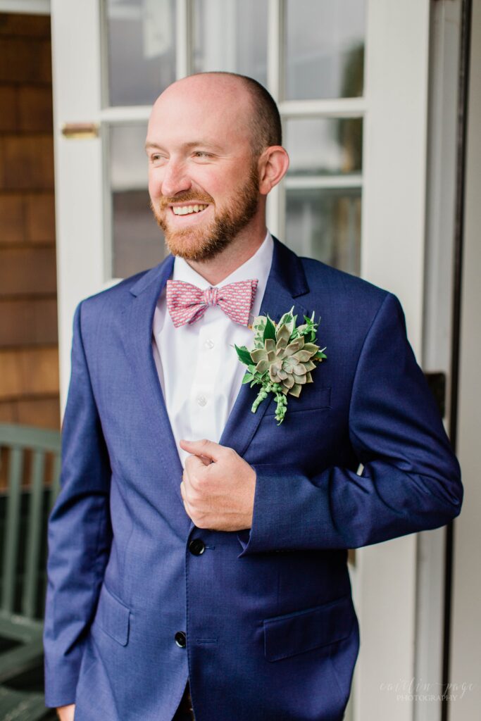 Groom standing with a navy blue suit on