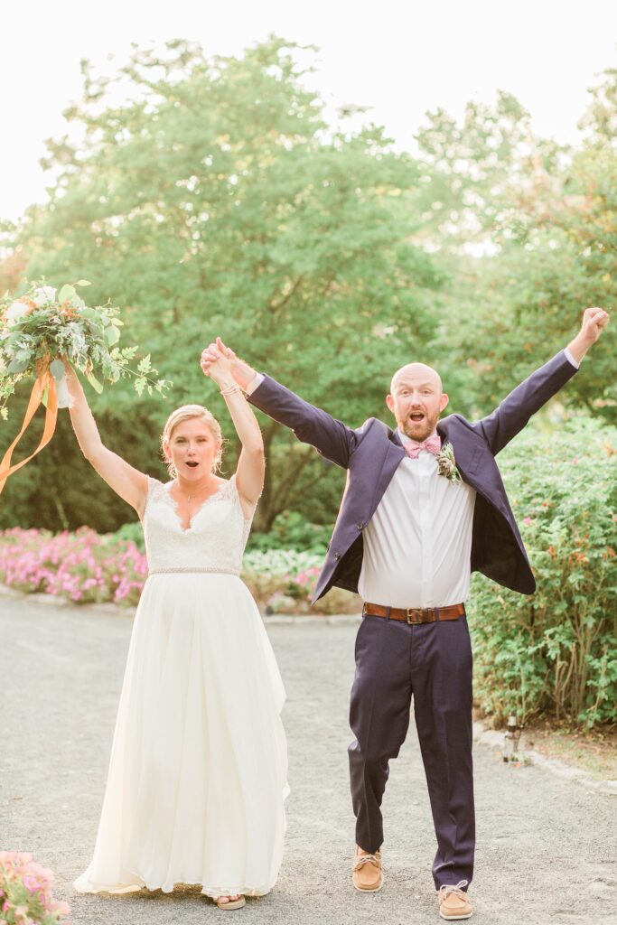 Excited bride and groom with their hands in the air