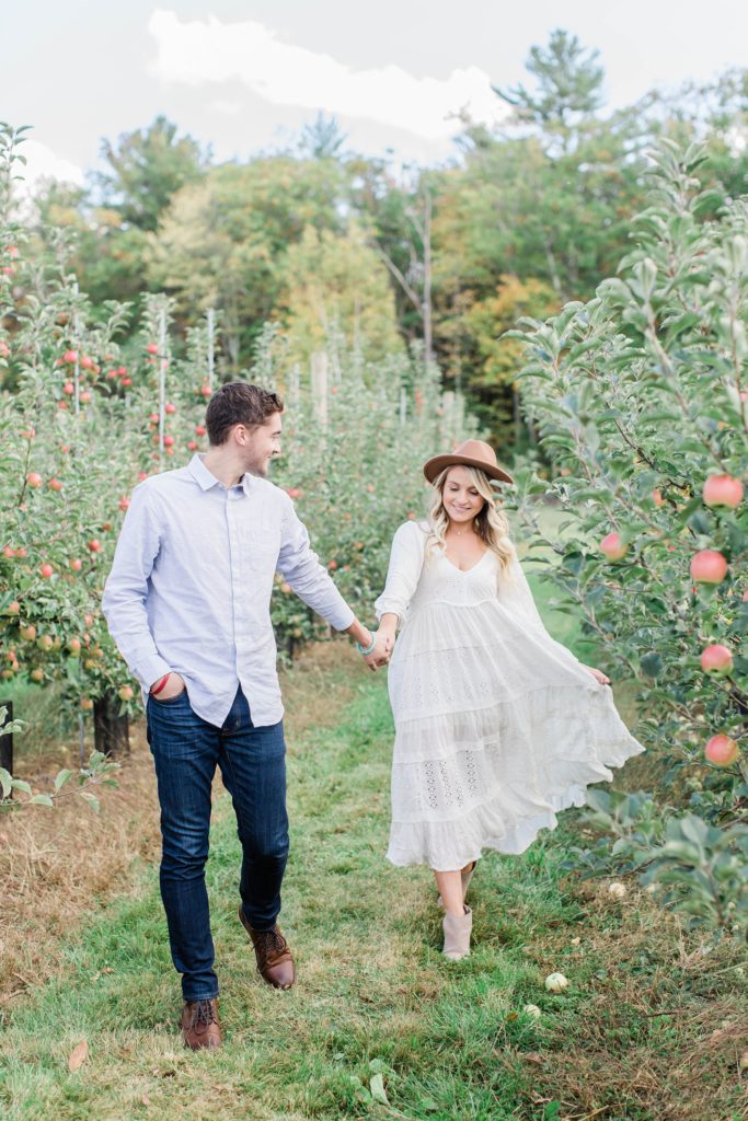 Man and woman walking through apple orchard