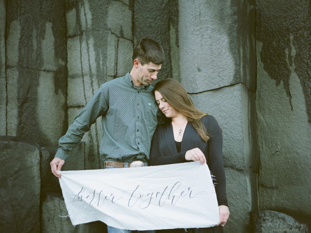 Man and woman standing on basalt cliffs
