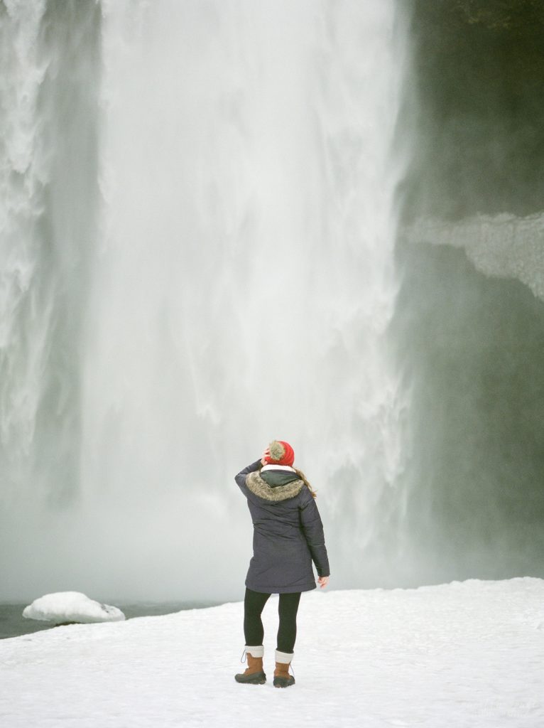 Woman standing in front of waterfall in Iceland
