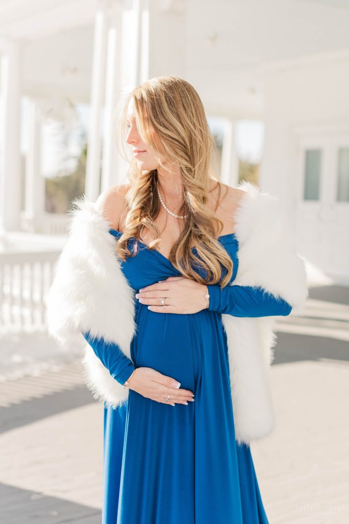 Pregnant woman in blue dress standing on balcony