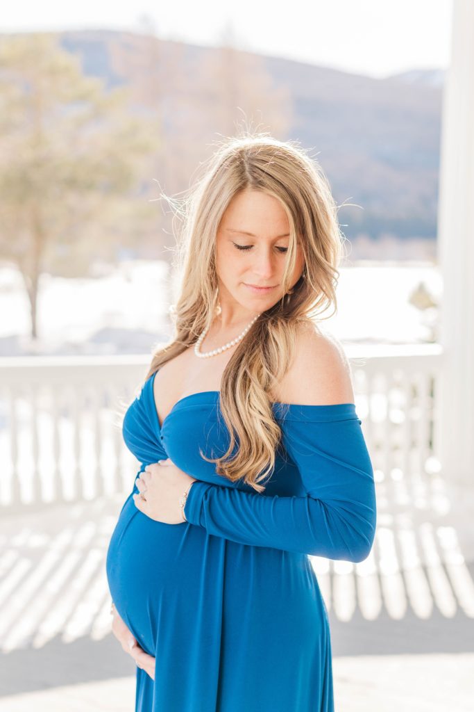 Pregnant woman in blue dress standing on balcony