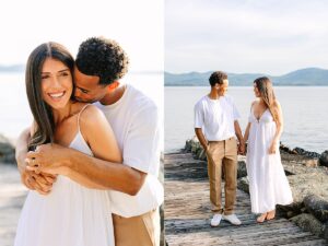 Man embracing a smiling woman from behind and kissing her shoulder, standing on a lakeside dock.